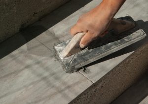 carreleur expérimenté qui fait les joints du carrelage